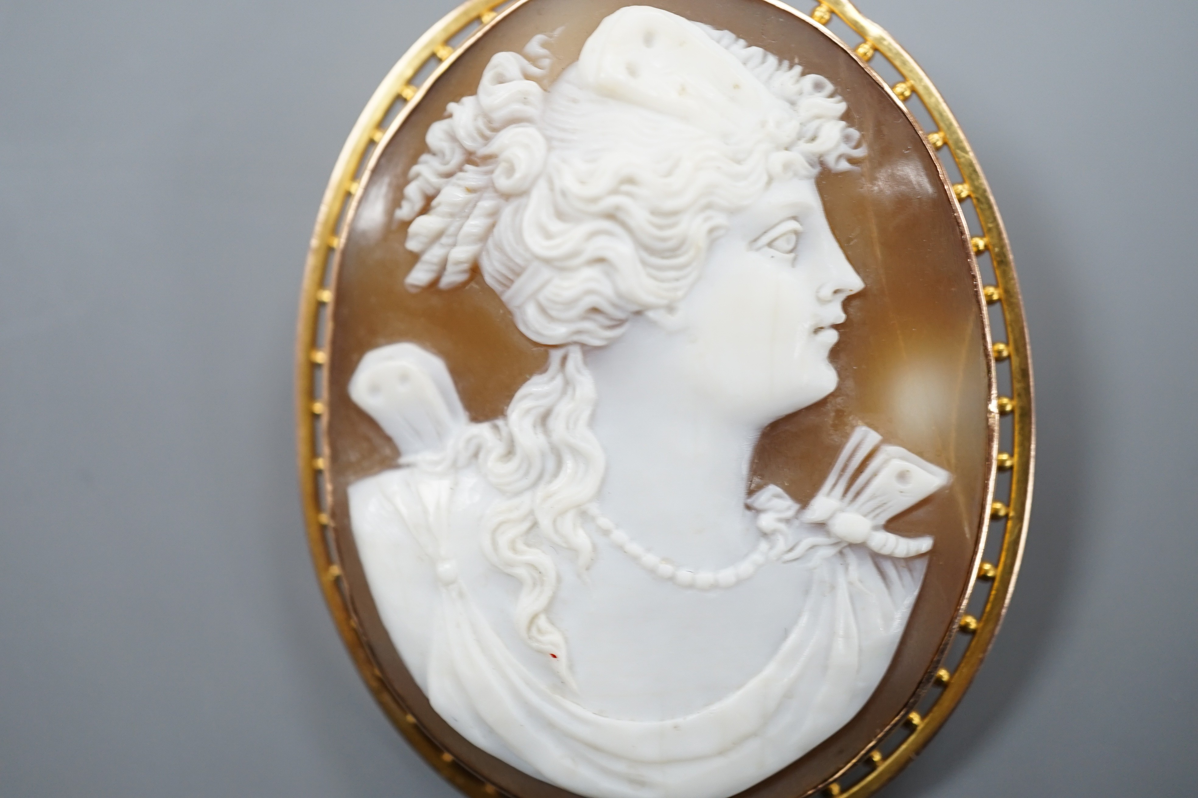 A 9ct mounted oval cameo shell brooch, carved with the bust of a lady to sinister, 5cm, gross weight 11.8 grams.